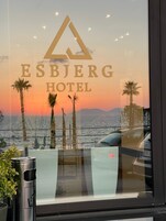 El cartel del Hotel Esbjerg con vista al atardecer a través de la ventana.