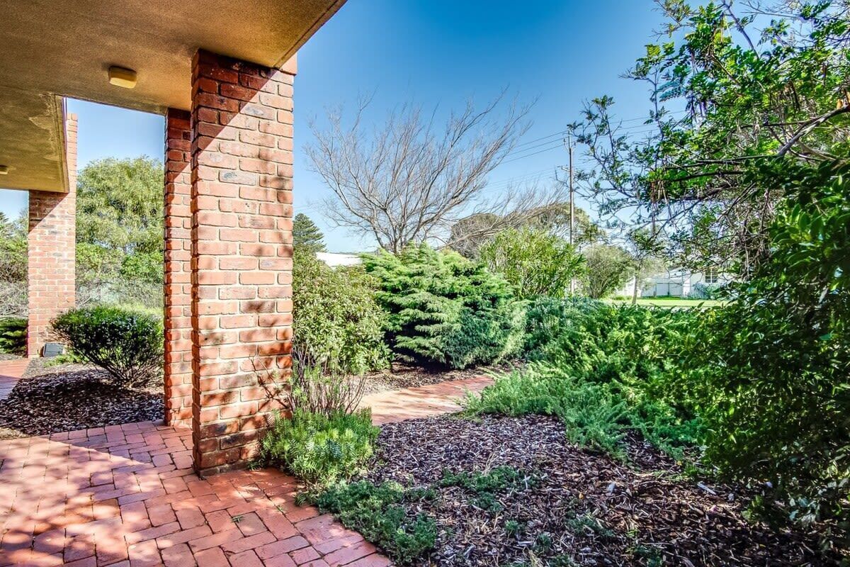 A brick exterior with a covered walkway leading to a building.