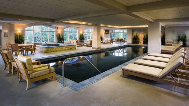 A pool area with lounge chairs, a dining table, and a hot tub. - Modern and Updated St James Premium 3 Bedroom Residence 3 Condo by RedAwning (Avon)
