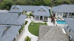Um imóvel residencial com vários edifícios, piscina e um jardim bem cuidado.