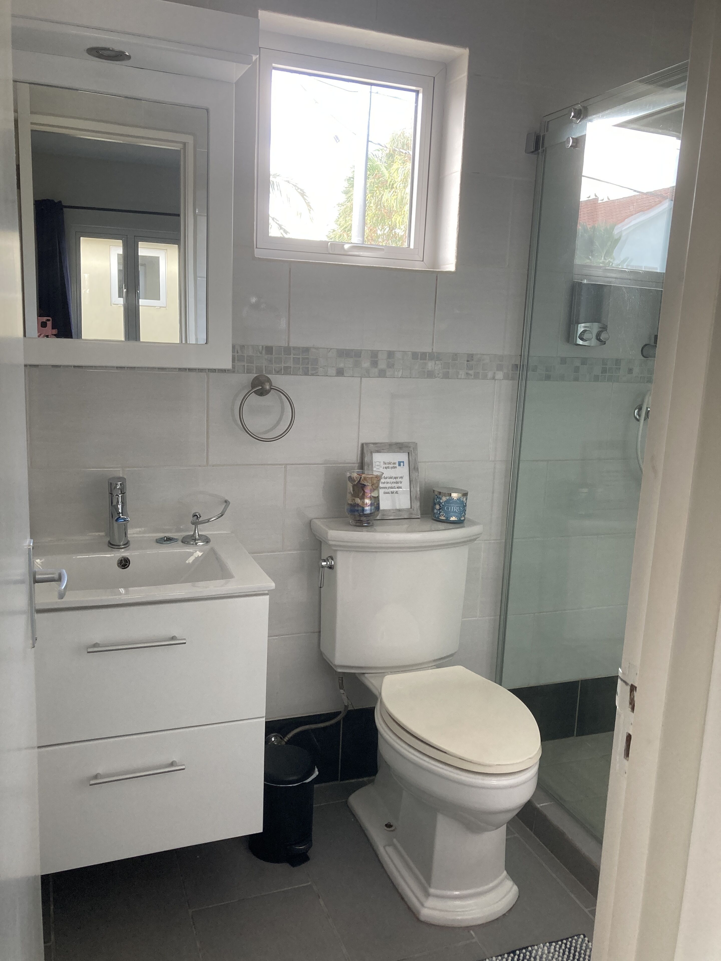 Ein modernes Badezimmer mit Toilette, Waschbecken und Dusche.