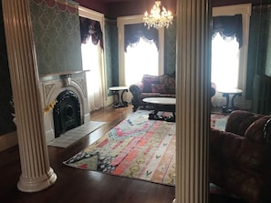A traditional living room with a fireplace, patterned rug, and classic furniture.
