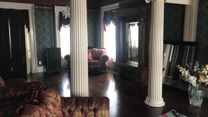 Un salon spacieux avec un grand canapé, une cheminée et une vue sur la salle à manger.