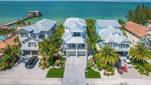 A coastal property with multiple houses, a dock, and a clear view of the ocean.