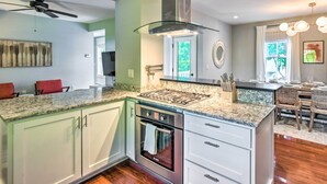 Una cocina moderna con estufa integrada, horno y encimera de granito.