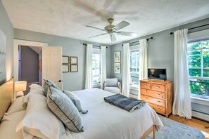 A bedroom with a bed, a ceiling fan, a dresser, and a TV. - Hot Tub + Walk to Lakeside Dining: Meredith Home! (Meredith)