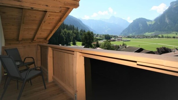 A wooden balcony with a view of a valley and mountains. - Panoramablick by Interhome (Mayrhofen)
