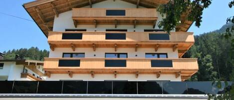 A multi-story building with a wooden facade and multiple balconies.