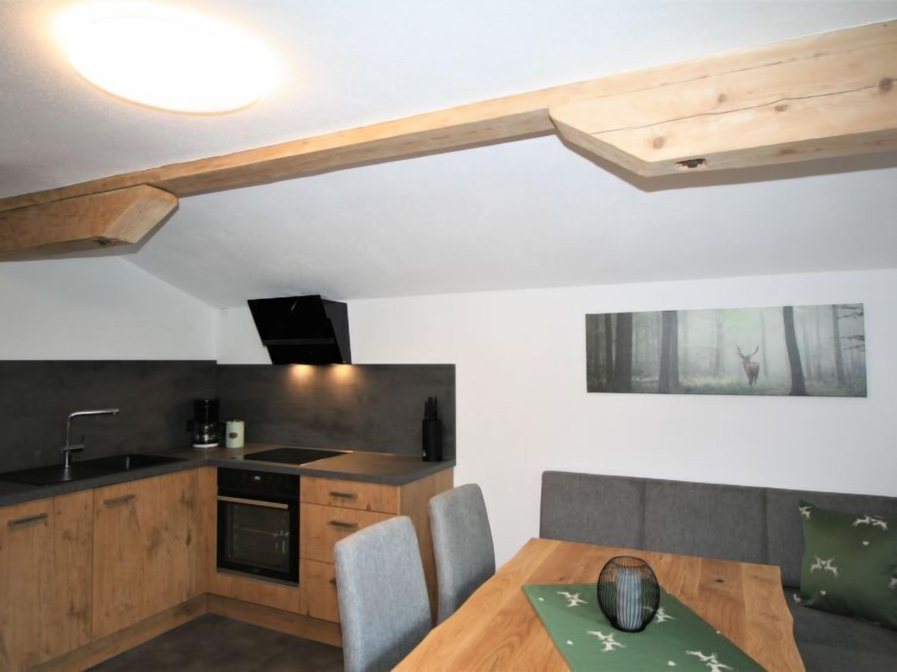 Une cuisine compacte avec des meubles en bois, un four encastré et un évier moderne.