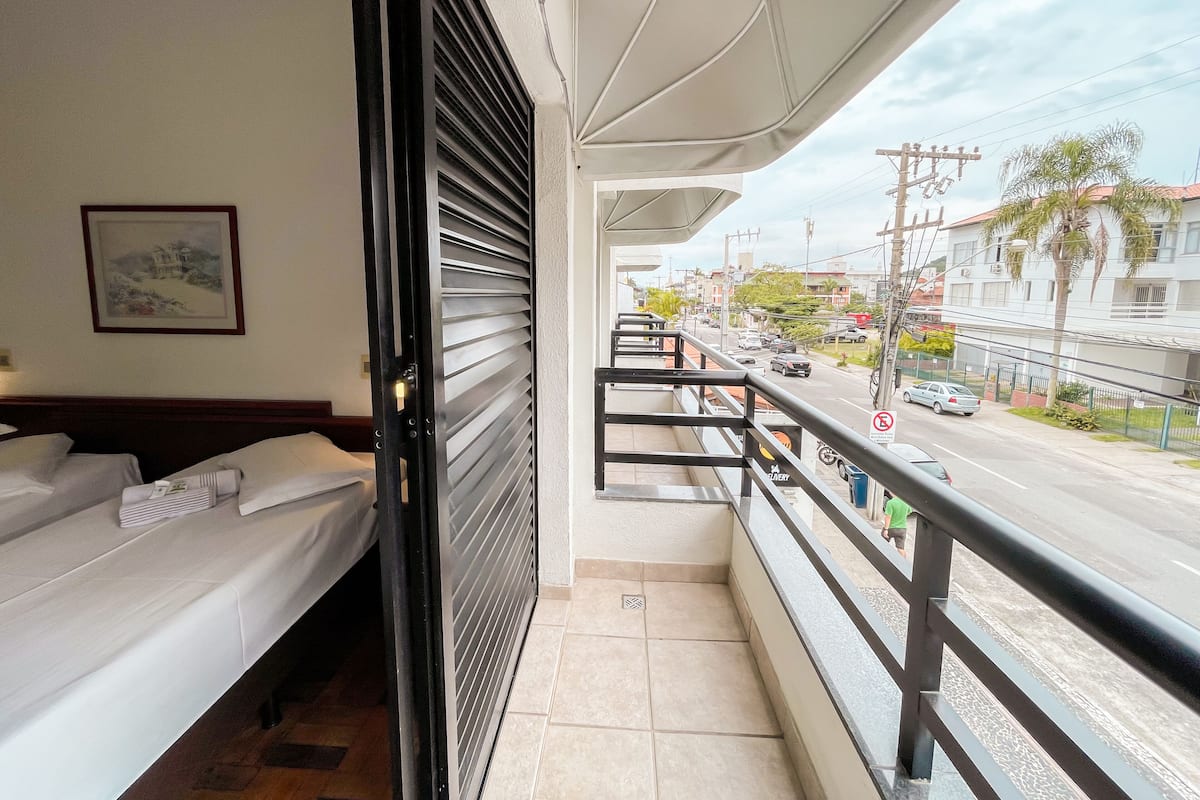 Un balcón con una cama, vista a la calle y un letrero de 'No Estacionar'.