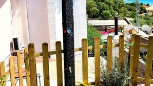 Un quartier résidentiel avec un bâtiment blanc, une gouttière noire et une clôture en bois.