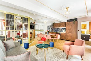 Ein modernes Wohnzimmer mit Essbereich, Küche und einem großen Fenster mit Vorhängen.