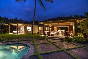 A modern house with a pool, outdoor seating area, and a covered patio.