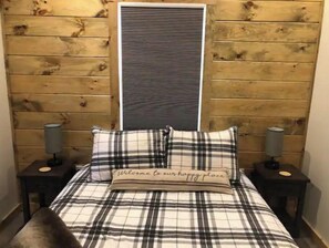 Cozy retreat with a plush bed, bedside tables, and a warm headboard.