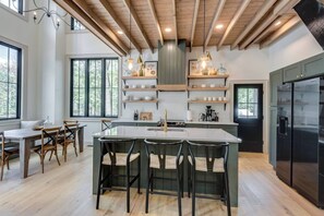 A modern kitchen with a central island, bar stools, and built-in appliances. - This house is a 3 bedroom(s), 2 bathrooms, located in Tracy City, TN. (Tracy City)
