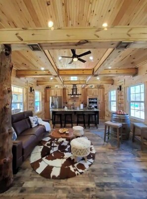 Relax in a cozy space with a leather sofa, wooden coffee table, and a bar area.