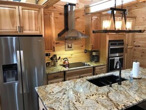 Fully equipped kitchen with an oven, microwave, and stainless steel appliances.