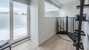 Ein modernes Interieur mit großen Fenstern, einer Treppe mit Metallgeländer und Blick auf eine verschneite Umgebung.