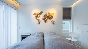 Ein Schlafzimmer mit einem großen Bett, einem Schreibtisch und einer Weltkarte an der Wand.
