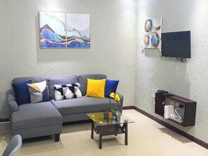 Relax in this stylish living room with a comfortable sofa, flat-screen TV, and cabinet.