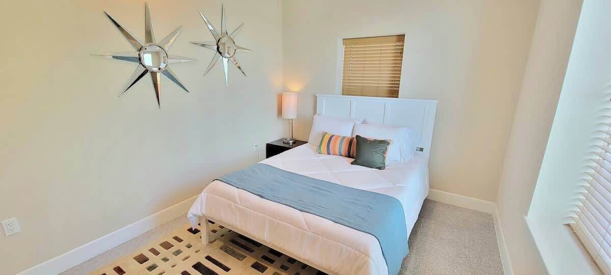 A bedroom with a bed, a nightstand, a lamp, and two wall-mounted star decorations.