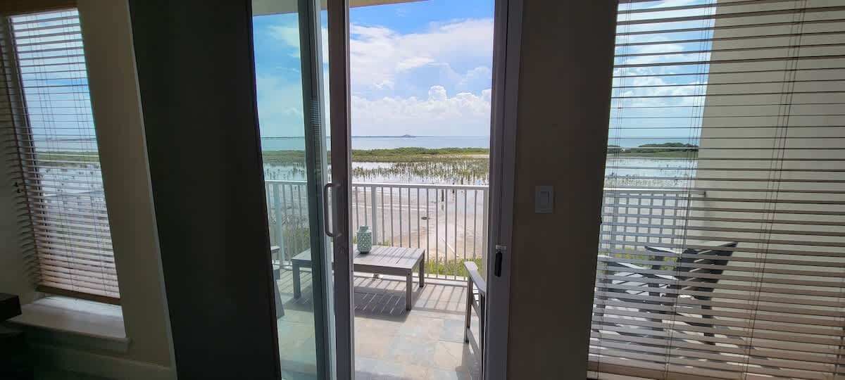 A balcony with a view of the beach and ocean.