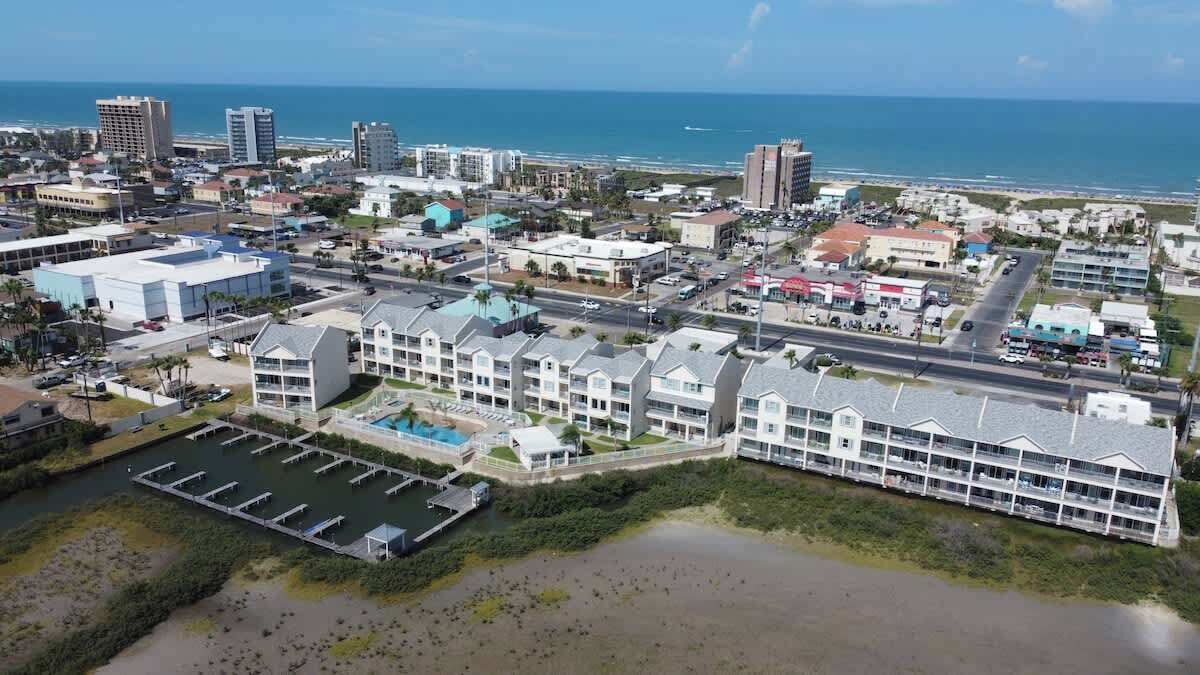 Un hôtel situé sur la côte, composé de plusieurs bâtiments, doté d’un parking et offrant une vue sur la plage et l’océan.