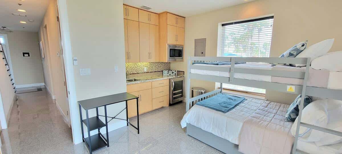 A compact room with bunk beds, a kitchenette, and a small table.