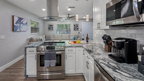 A modern kitchen with a central island, stainless steel appliances, and a built-in oven. - 2BR Apt, 5 Min to Busch Gardens | Unit B, Sleeps 6, Remodeled, Tampa (Tampa)