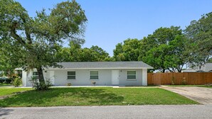 A single-story house with a front yard, a driveway, and a wooden fence. - 2BR Apt, 5 Min to Busch Gardens | Unit B, Sleeps 6, Remodeled, Tampa (Tampa)