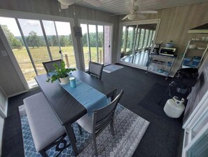 Enjoy meals on the patio with a dining table for two, a potted plant, and a fully equipped kitchenette.
