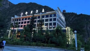 Un hotel con fachada moderna, ventanas amplias y un letrero con caracteres chinos.