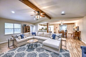 Relax in this inviting living area with a large L-shaped sofa, coffee table, and dining space.