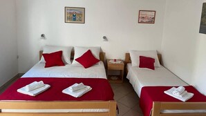 A hotel room with two beds, each with red and white bedding, and two white towels on the beds. - Cosy Apartment Near the Beach in Medulin, Croatia (Medulin)