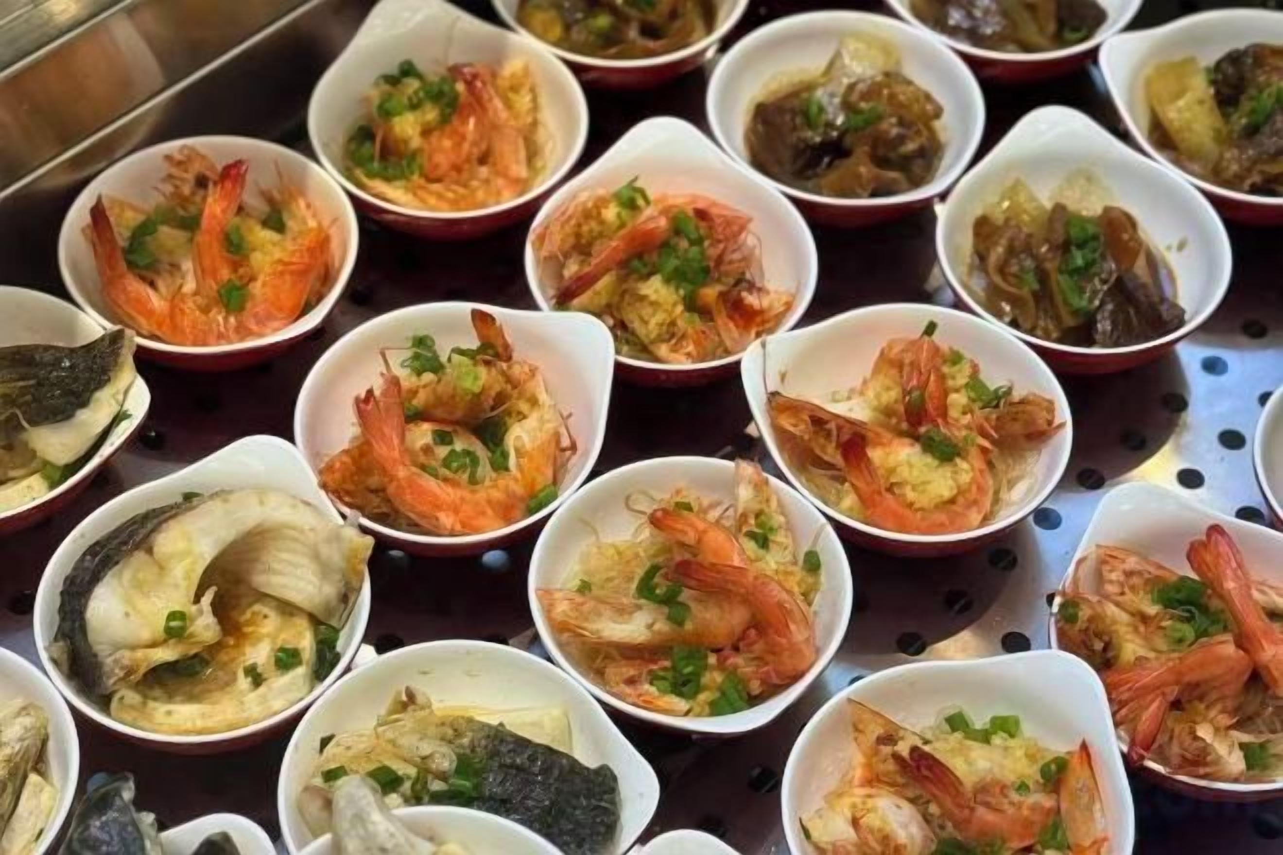 Une variété de plats de fruits de mer servis dans de petits bols.