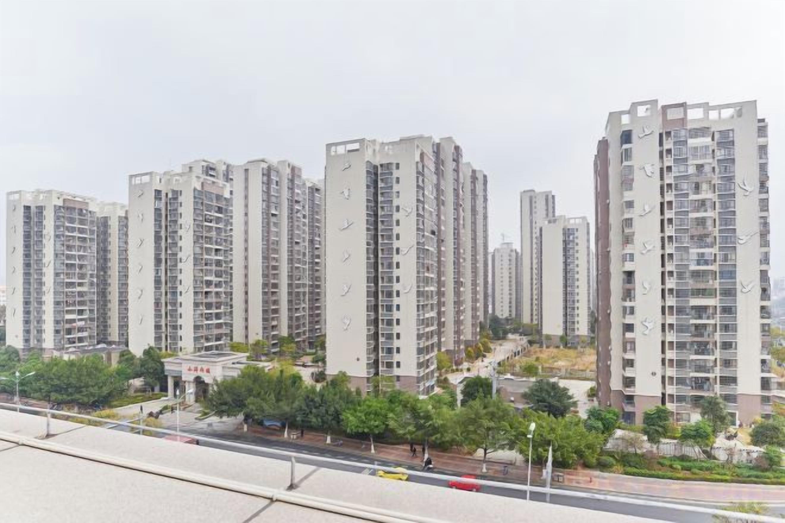 Un edificio residencial alto con varios pisos, balcones y un diseño de techo plano.