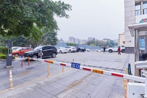 Un estacionamiento con automóviles y un edificio al fondo.
