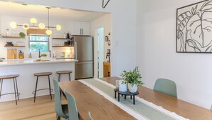 Une cuisine moderne dotée d’un îlot central, de tabourets de bar et d’une table à manger avec des chaises.