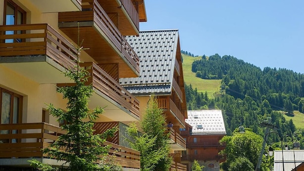 A multi-story building with wooden balconies and a view of a green hillside. - 100m from ski slopes, Ground floor, balcony, 29m², Valloire (Valloire)