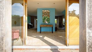 An open interior space with a blue wall, a wooden bench, and a stone wall decoration. - Goodwood Revival 6 Bed Retreat, Secure Parking (Birdham)