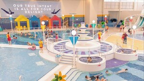 Un parc aquatique intérieur doté de plusieurs piscines, de toboggans et d’aires de jeux.