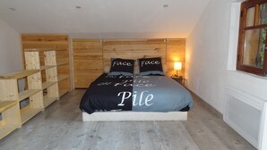 Ein Schlafzimmer mit einem Bett, Holzregalen, einem Nachttisch und einem Fenster.