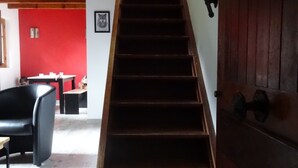 Eine Holztreppe mit Metallgeländer, die zu einer Zwischenebene führt.