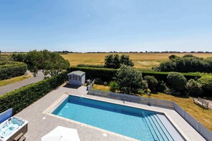 A rectangular swimming pool with a surrounding deck, a small shed, and a white fence. - Beach house with pool in West Wittering (West Wittering)