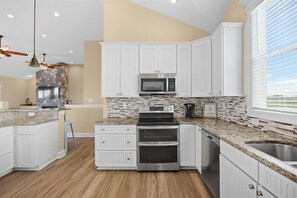 Enjoy cooking in this well-equipped kitchen with a large island, stainless steel appliances, and plenty of natural light.