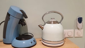 A coffee maker and a kettle on a wooden table. - Comfort studio - Double bed + single bed - FAME MARINA BAIE DES ANGES (Villeneuve-Loubet)