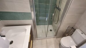 A bathroom with a glass-enclosed shower, a bathtub, and a toilet. - Comfort studio - Double bed + single bed - FAME MARINA BAIE DES ANGES (Villeneuve-Loubet)