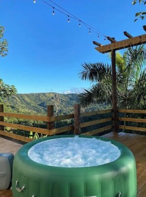 Relax in a hot tub on a deck with a breathtaking mountain view.