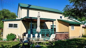 A two-story house with a porch and a covered patio area. - Mill town location by the river w/hot tub (Bonner-West Riverside)