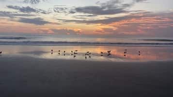 Na praia, espreguiçadeiras, toalhas de praia